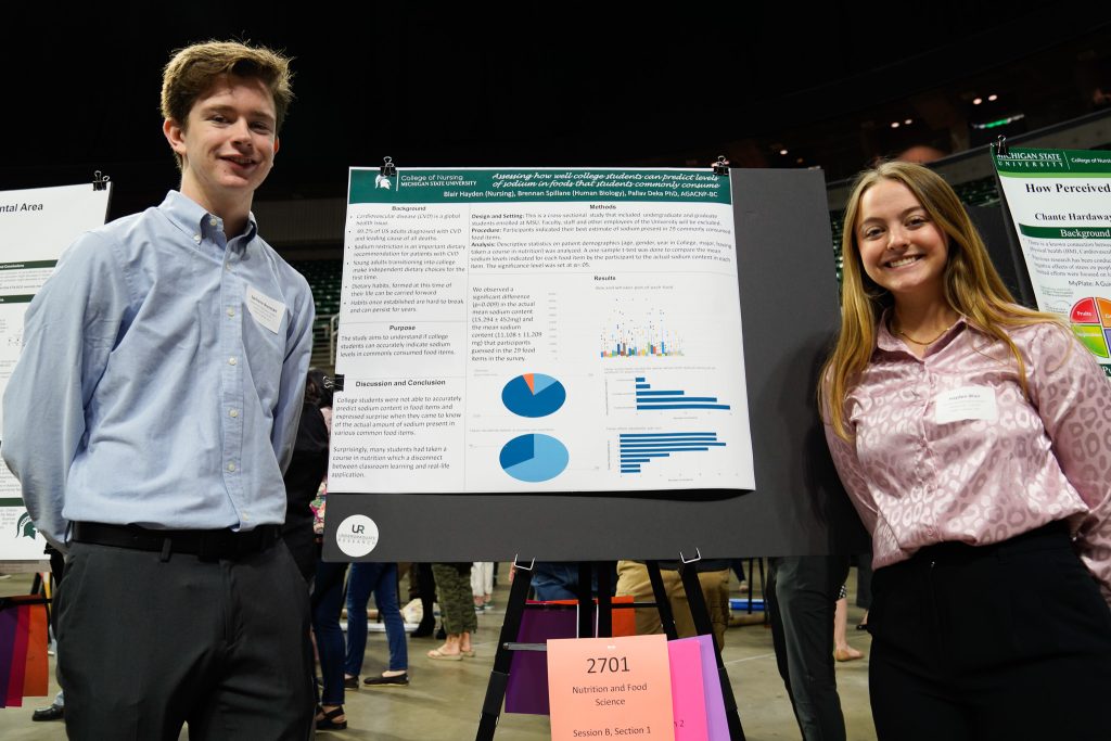 Nursing second-year Blair Hayden and human biology third-year Brennan Spillane in front of their UURAF poster on April 14, 2023.