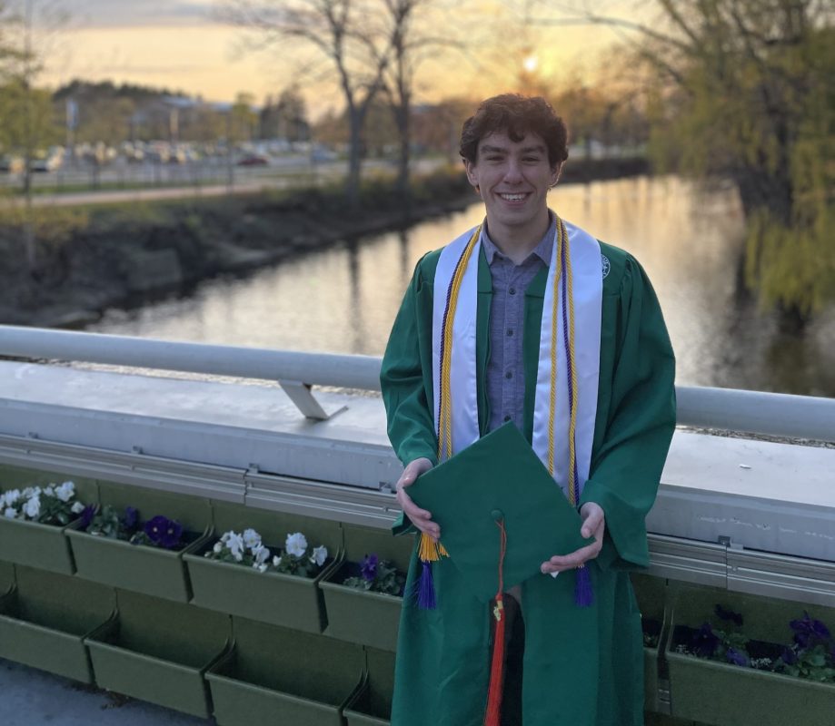 Riley Lawson in cap and gown by red cedar river