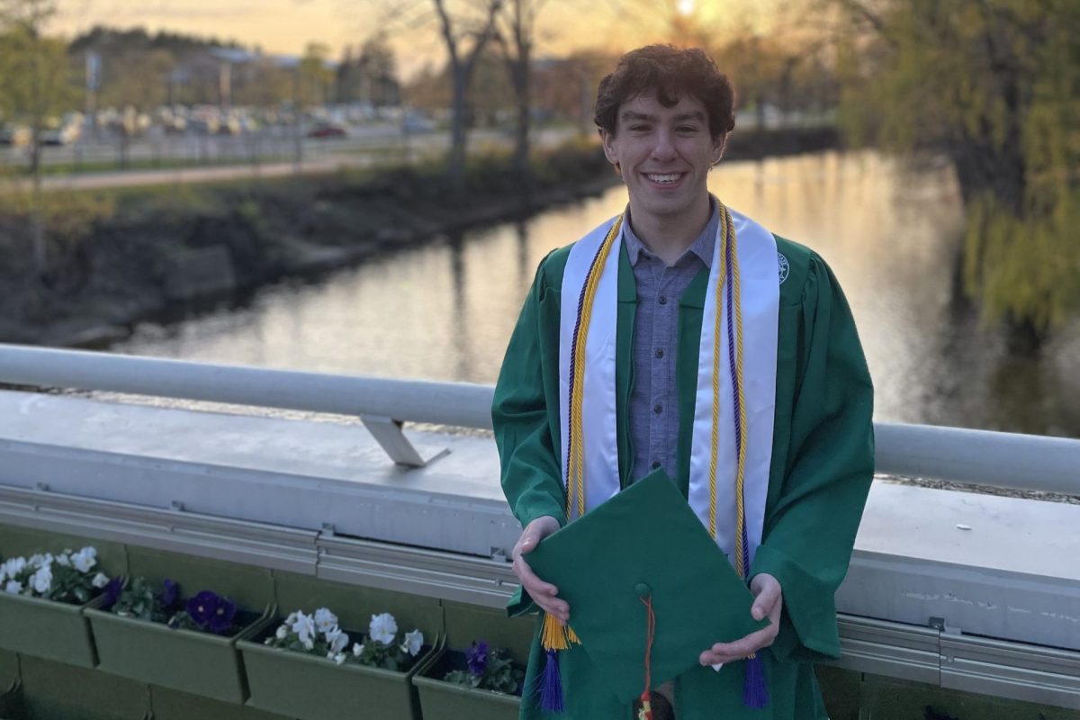 Riley Lawson in cap and gown by red cedar river