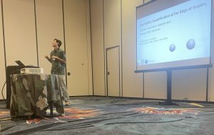 Andrew Yeomans-Stephenson presents his project "Uncertainty Quantification at the Edge of Stability" at the conference in Hawaii. 