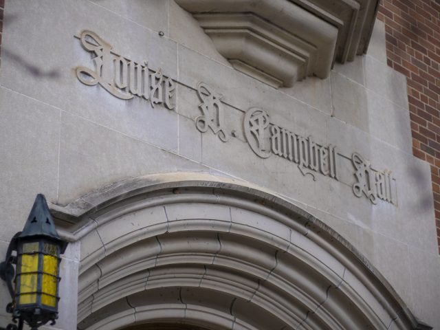 A close up of the words Louise H. Campbell Hall carved in stone above an entrance to the residence hall