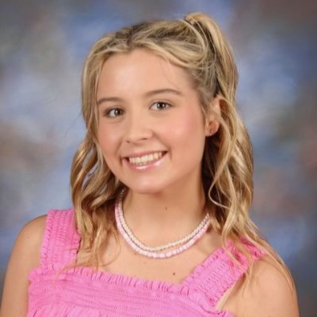 Formal headshot of Kayla Norman in a pink top, smiling.