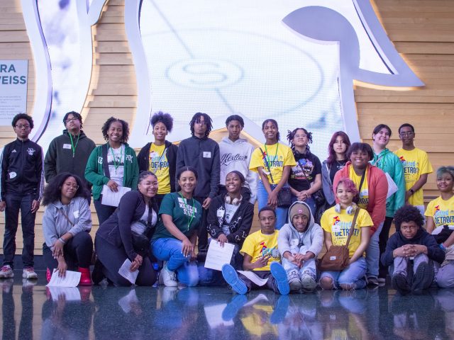 A group of students posing for a photo in front of a giant white Spartan head.