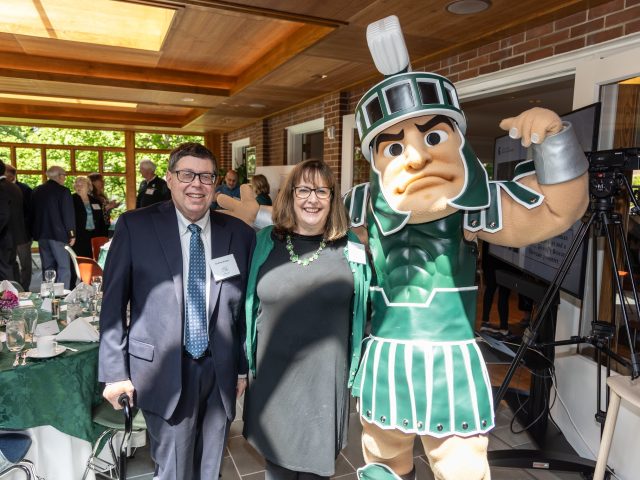 Andrew and Carolyn Bratzel pose with Sparty at the Campbell Hall Groundbreaking event.