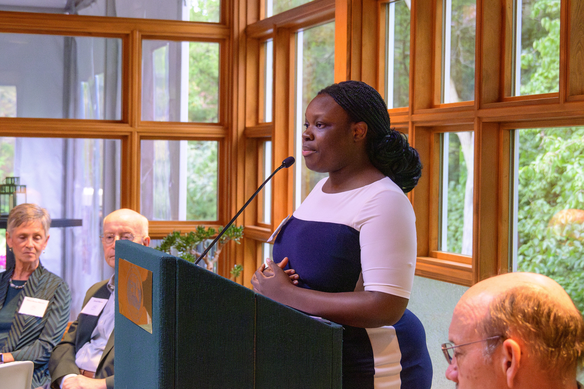 Jeanette Dompreh speaks from a podium to the audience inside Cowles House.