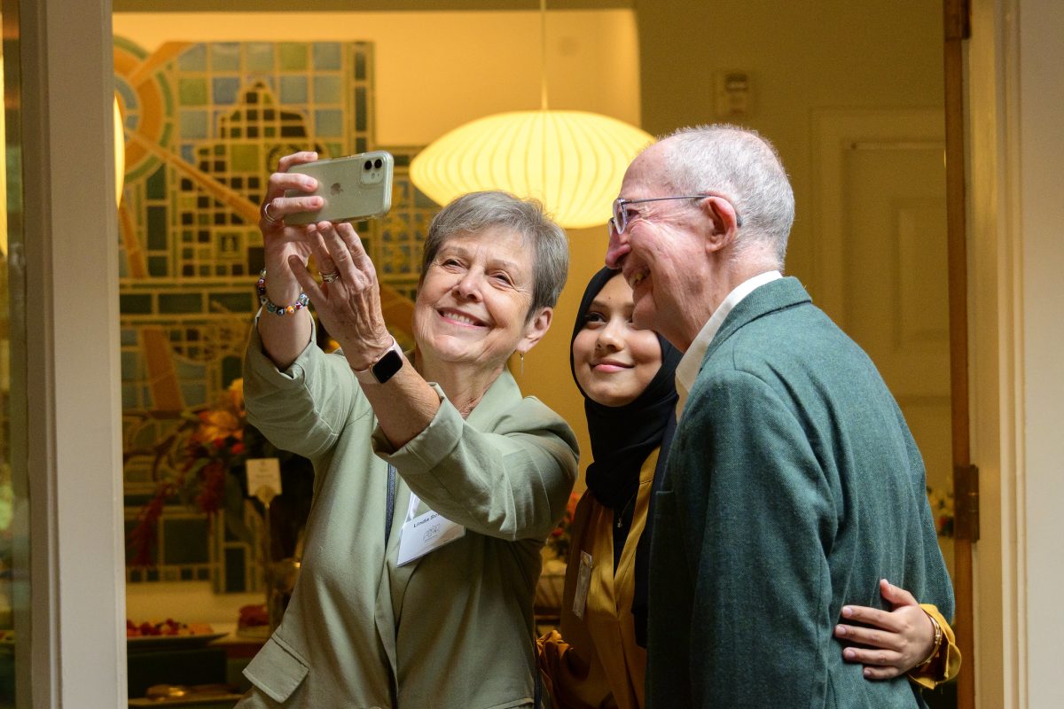 Two donors take a selfie with their scholarship recipient inside Cowles House.