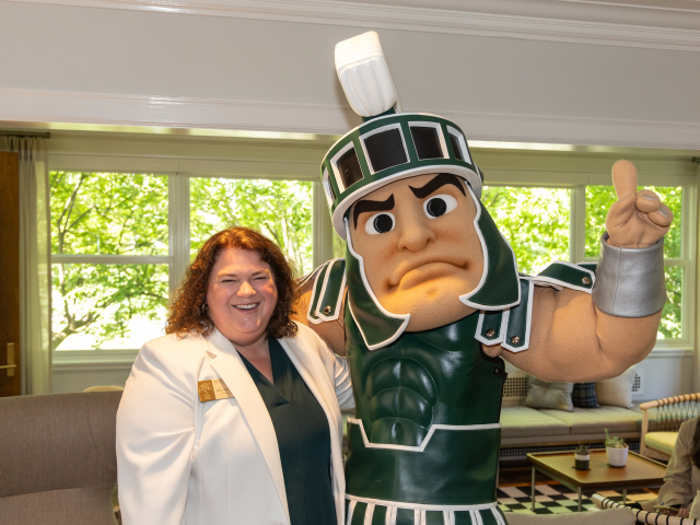 Assistant Dean Bess German posing with Sparty at the Campbell Hall groundbreaking ceremony in 2024