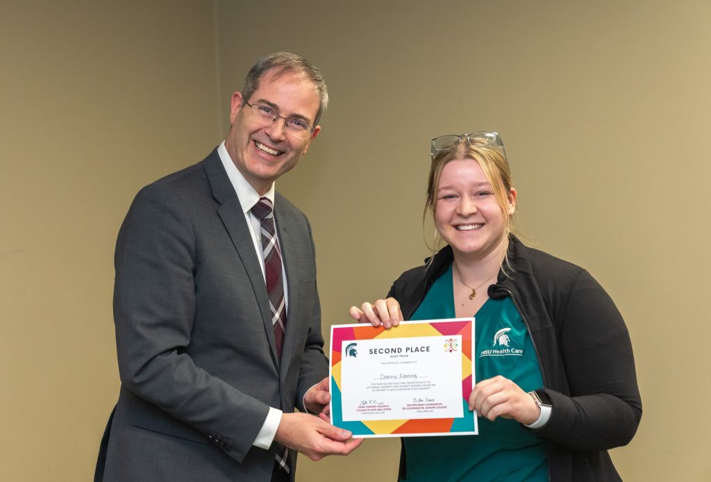 Dean Christopher Long and Destiny Kanning in 2023, smiling with an award certificate.