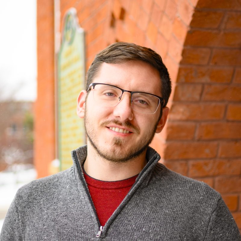 Portrait of Brett Binkowski in front of Eustace Cole Hall.