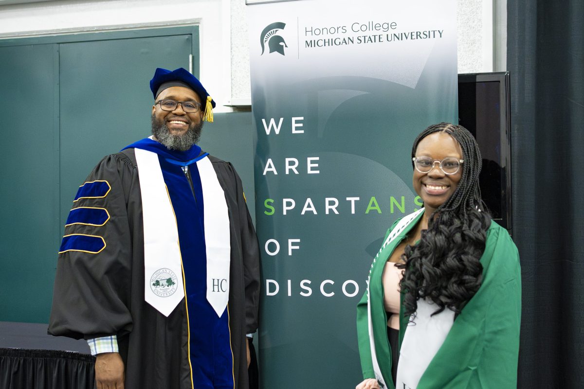 Jeannette Dompreh at graduation smiling with Interim Dean Chambers.