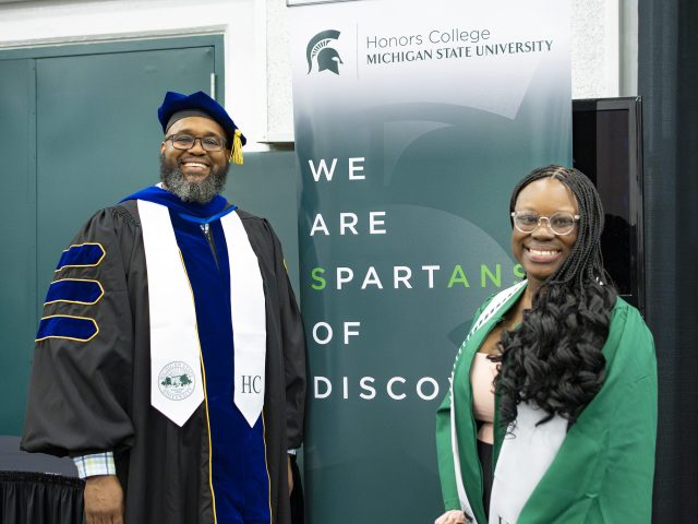 Jeannette Dompreh at graduation smiling with Interim Dean Chambers.