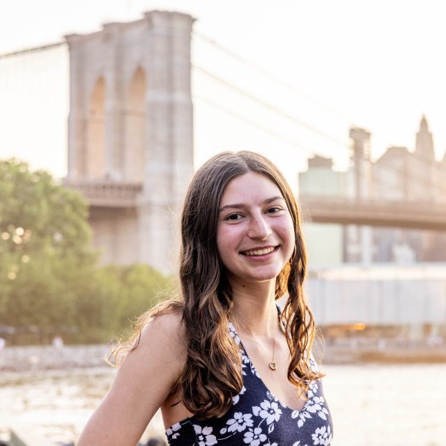 Alexandra Watson profile photo in front of a city skyline on the waterfront.
