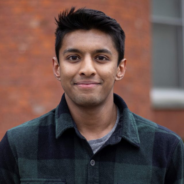 Aaron Philip headshot in front of eustace cole hall.