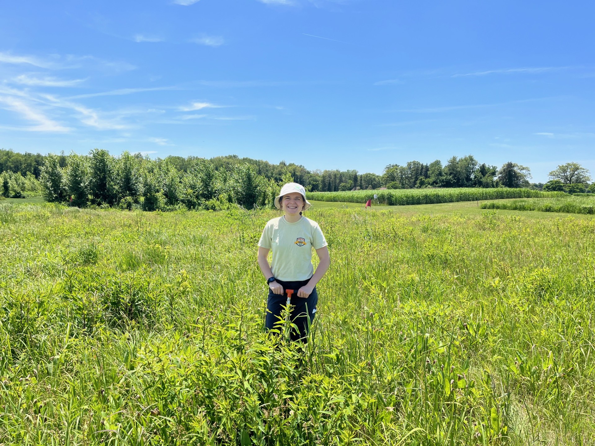 Rachel Drobnak in a green field with a blue sky above.