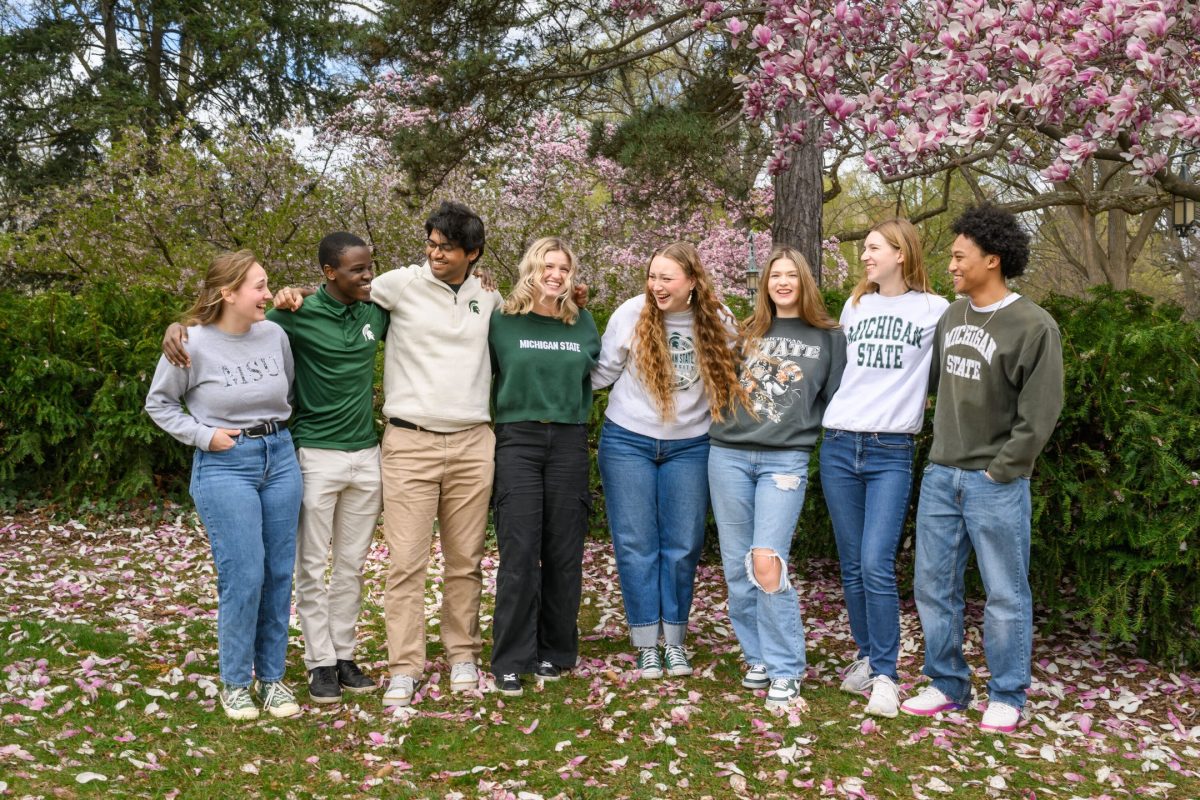 Group photo of the 8 Honors homecoming court members outside laughing together.