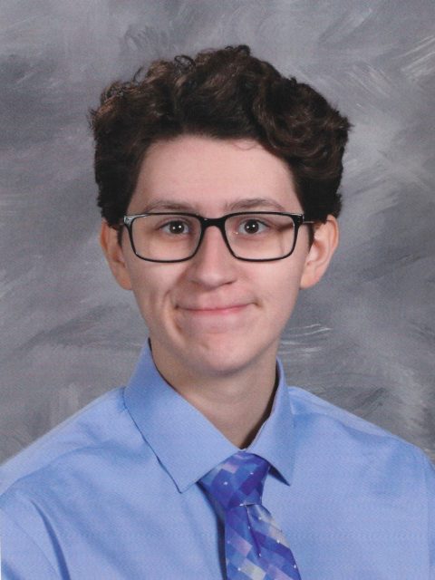 Professional image of incoming MSU Honors College student and Williams Scholar Ezra Duncombe in a blue collared shirt and colorful necktie against a grey background.