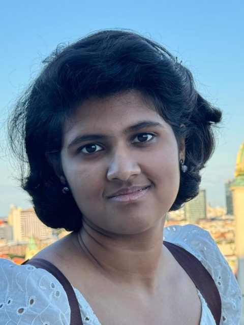Image of incoming MSU Honors College student and Williams Scholar Swastika Prakash Srivastava in a white floral top, with buildings in the background.