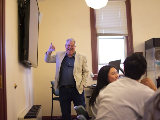 Honors College alumnus Tom Wielenga standing and enthusiastically presenting to a cohort of Honors Research Scholars.