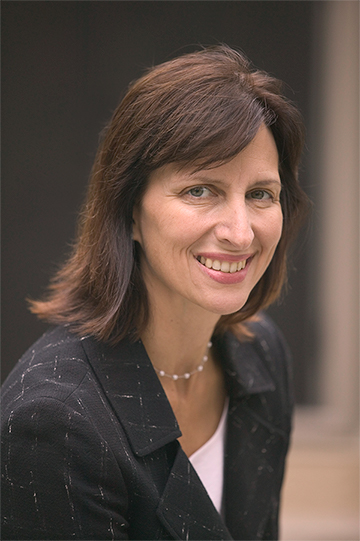 Christi Rager Wise smiling in a black patterned blazer.
