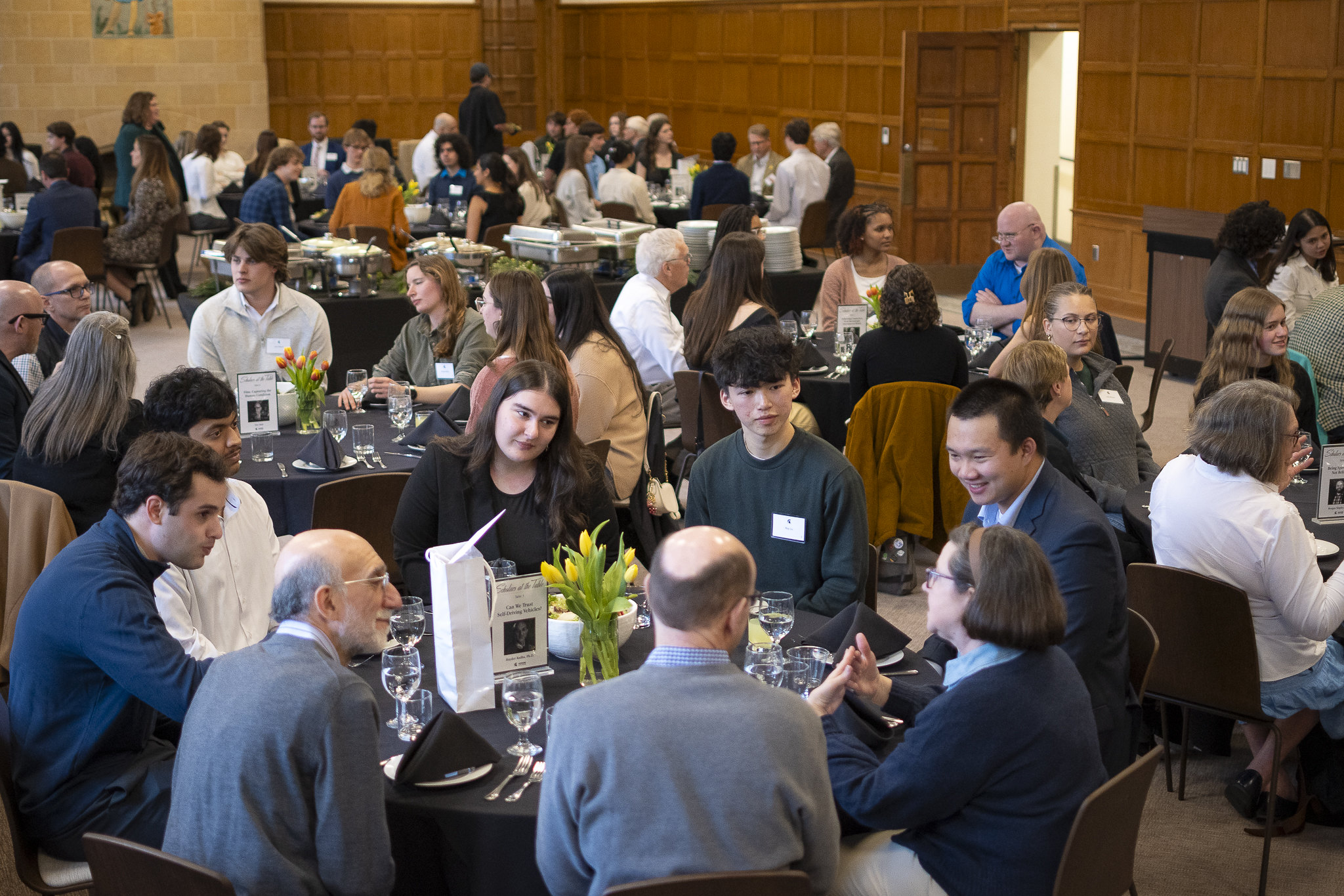 Roundtable discussions occurring between Honors College alumni, staff, and students in the Porteous Grand Hall at Campbell Hall.