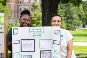 Photo of two students standing behind FGHA club sign at the Honors College Resource Fair.