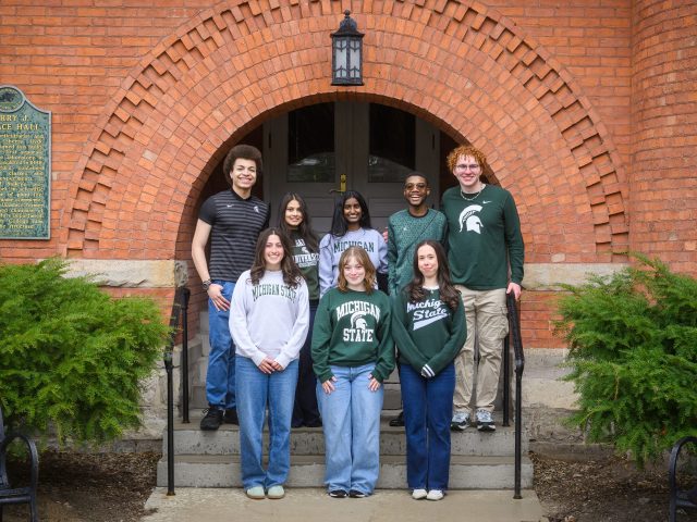 Honors College students of the 2026 Homecoming Court standing and smiling in front of Eustace-Cole Hall, wearing Michigan State attire.